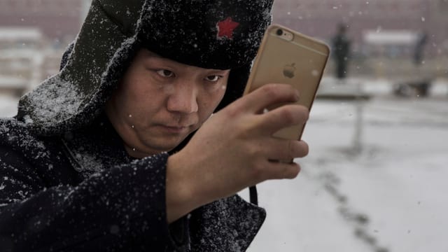 Ein Mann mit Pelzmütze macht ein Selfie.