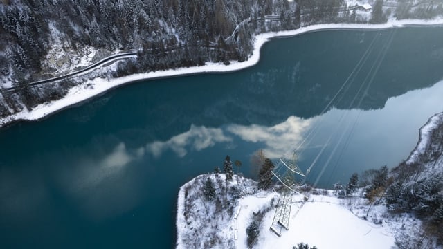 Blick auf den Stausee Mapragg der Axpo und einen Strommasten.