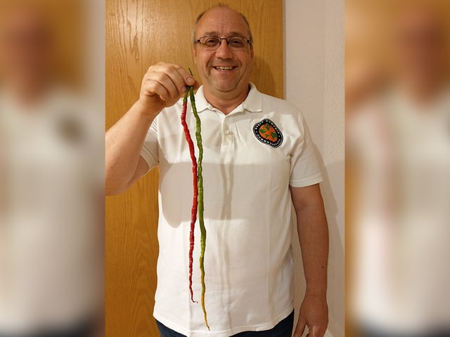 Jürg Wiesli hält die längste Chili der Welt in der Hand