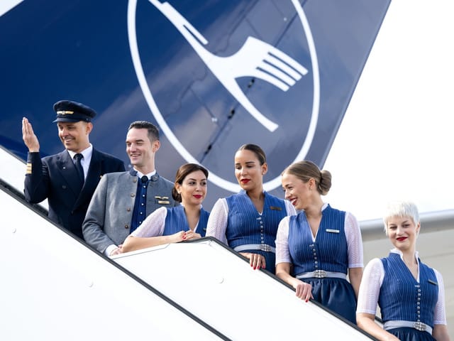 Flugbegleiter, Pilot und Co-Pilot posieren auf einem Gang-Way (Treppe aus einem Flugzeug).