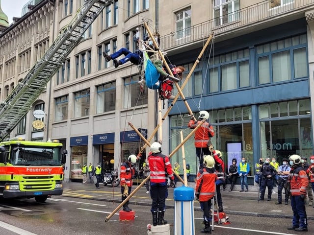 Zu sehen Feuerwehrkräfte und Demonstrierende in Zürich.