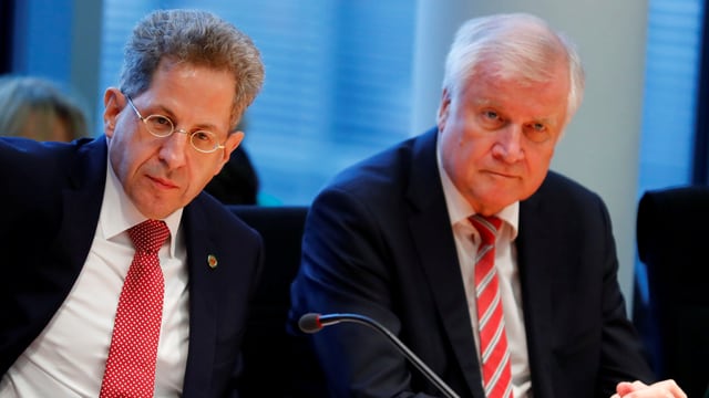 Hans-Georg Maassen und Horst Seehofer sitzen an einem Tisch vor Mikrofon.