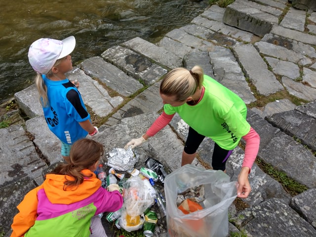 Plogger sammeln Abfall ein am Fluss