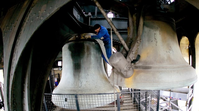 Mann reinigt Glocke.