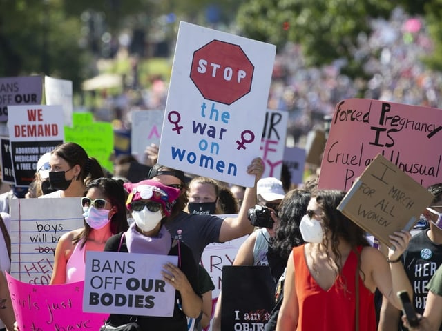 Frauen mit Protestschildern.