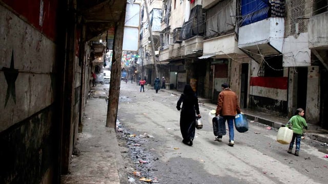 Menschen mit Kanistern in der Strasse von Aleppo.