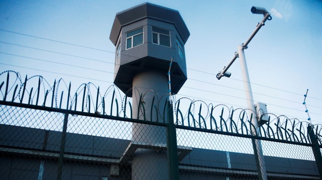 Wachturm und Stacheldrahtmauer eines Umerziehungslagers.