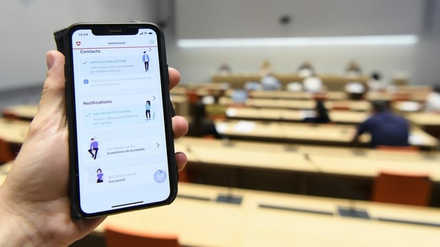 A hand holds the SwissCovid Contact Tracing app on his smartphone on camera, photographed during a press conference.