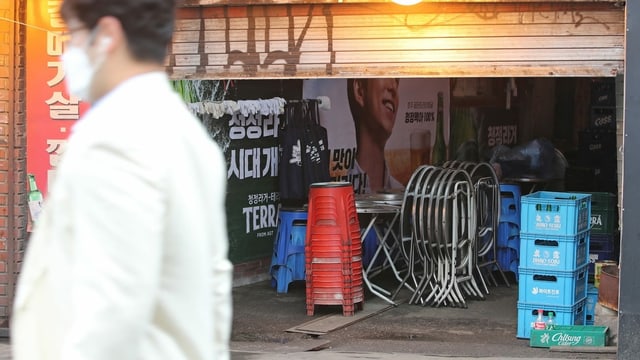 A man passes a closed bar in Seoul, South Korea.