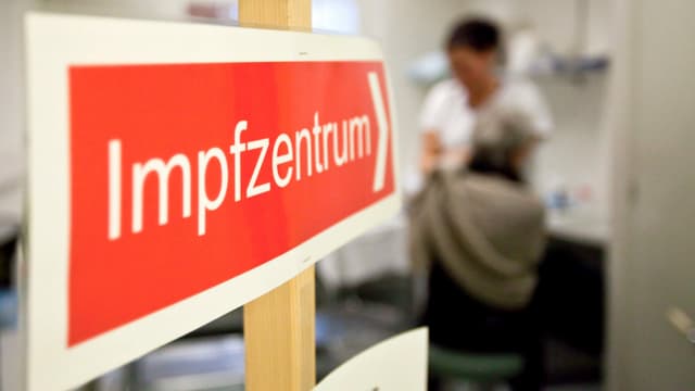 Es wird ein Schild mit dem Vermerk Impfzentrum gezeigt