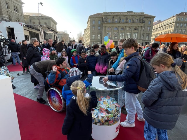 Besucher stehen um die Spendebox um Spenden einzuwerfen