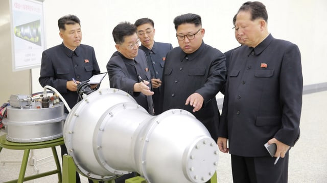 Nordkoreas Machthaber Kim zeigt auf einen Metallbehälter