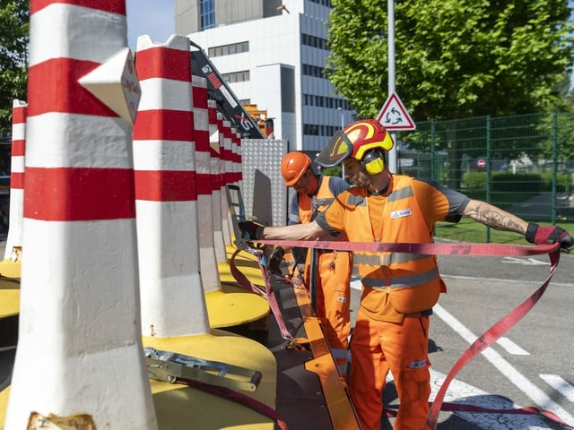 Arbeiter machen Betonelemente für Wegtransport bereit.