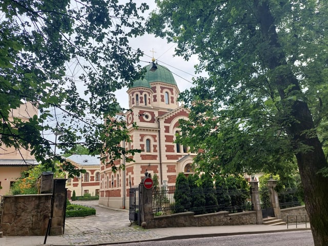 Kirche von aussen hinter Bäumen