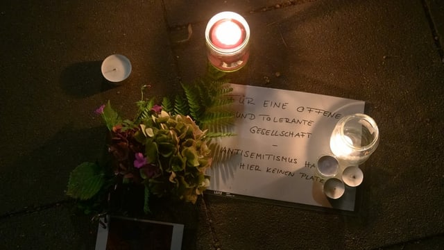 Flowers and candles and a note with the title. 