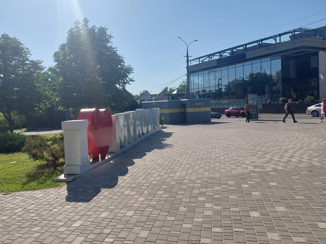 I ❤️ MYKOLAIV-Skulptur auf einem gepflasterten Platz neben einem Gebäude