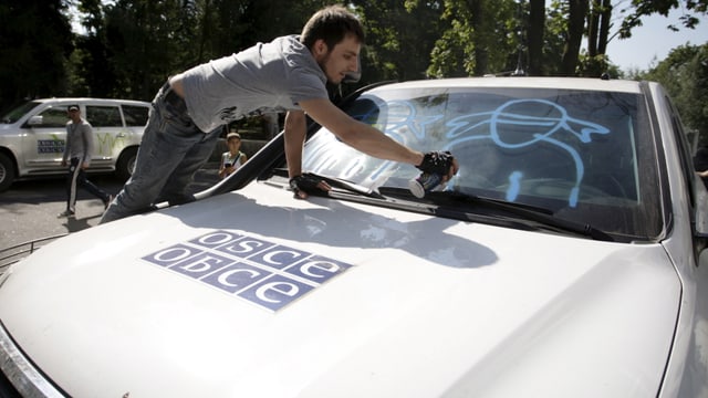 Mann sprayt auf Scheibe von OSZE-Auto