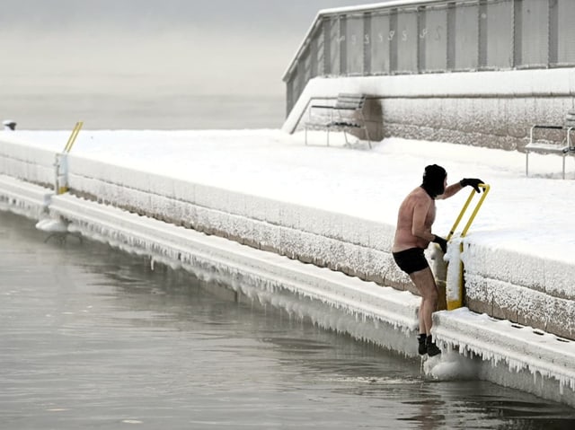 Ein Mann steigt ins Wasser. 