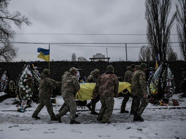 Kameraden tragen den Sarg des ukrainischen Soldaten Serhij Pawllichenko auf einem Militärfriedhof in Kiew. 