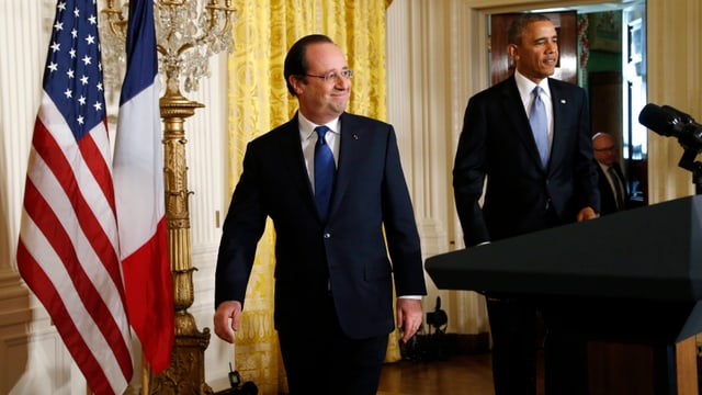 Hollande und Obama verlassen das Podium nach einer Pressekonferenz anlässlich Hollandes Besuch bei Obama letzten Februar, im Hintergrund die US- und Frankreichfahne.