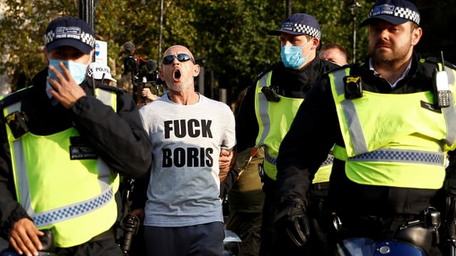 to see a protester and police officers in London.