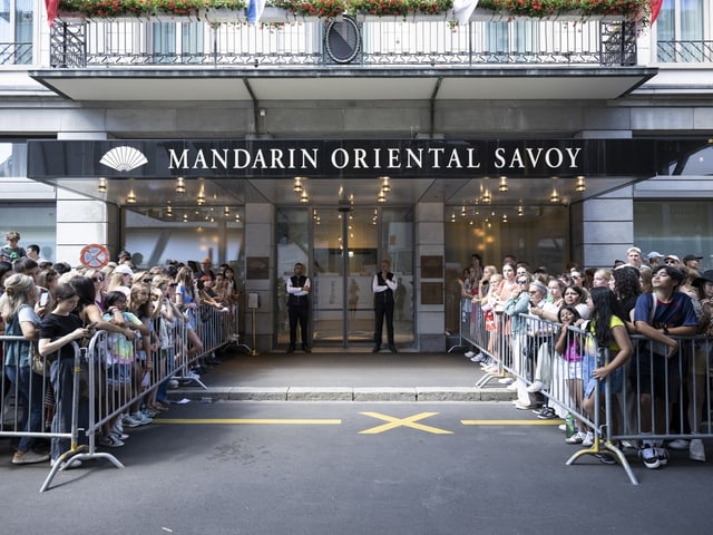 Menschenmenge vor dem Hotel Savoy in Zürich hinter Absperrgittern.