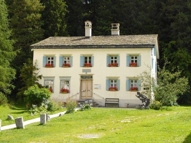 Das kleine Nietzsche Haus in Sils Maria vor einem Waldstück.