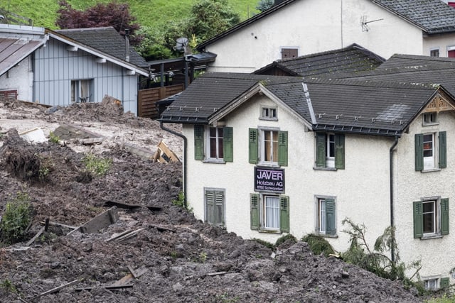 Meterhoher Schlamm- und Dreckwall um ein Haus in Schwanden