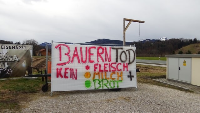 Ein Galgen steht hinter einem Protestplakat «Bauerntod kein Fleisch, Milch, Brot».