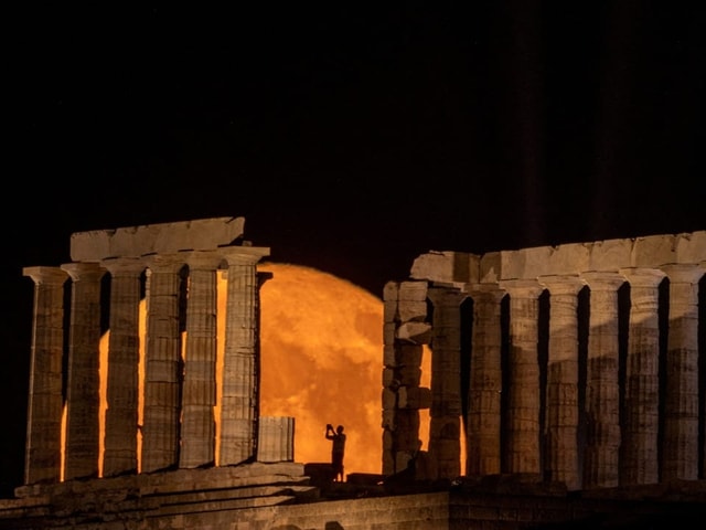 Der Vollmond hinter einem Tempel.