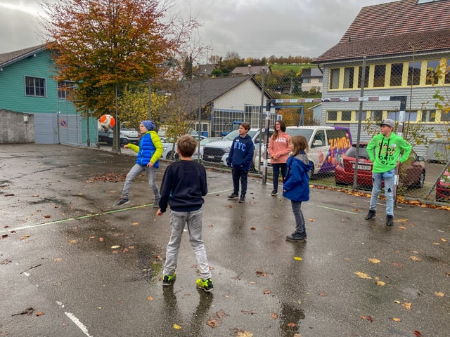 Kinder spielen Fussball auf dem Pausenplatz