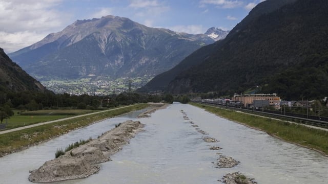 Fluss in einem Tal mit Bergen im Hintergrund.