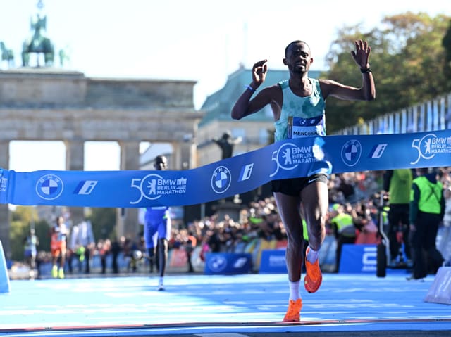 Läufer überquert die Ziellinie beim Berlin Marathon.