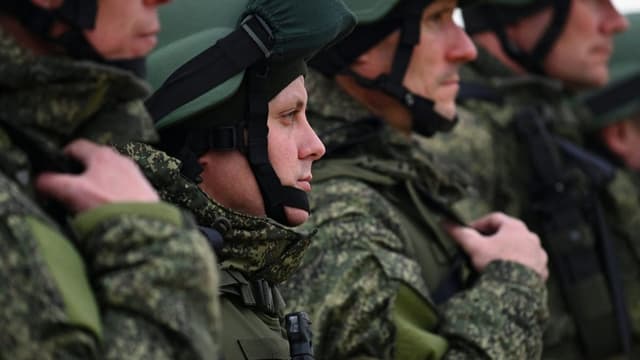 Reservisten stehen in Reih und Glied: eine Nahaufnahme. Sie tragen Helm und Uniform.