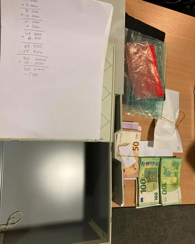 Tisch mit Papier, Bargeld, Umschlag und Tüten.