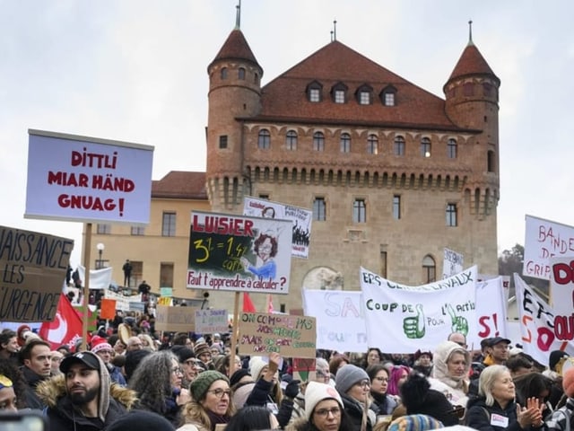 Waadt: Menschen protestieren mit Plakaten.