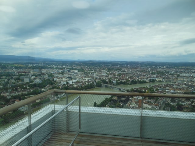 Blick auf die Altstadt von Basel von einem Hochhaus. Im Vordergrund eine Terrasse.