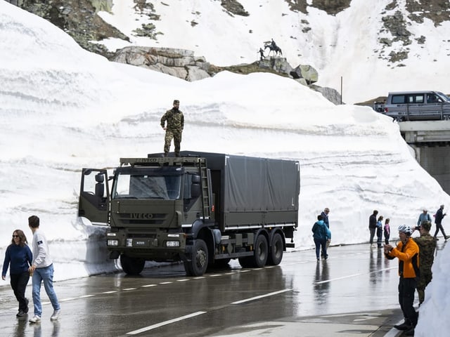 Autos vor hohen Schneemassen.