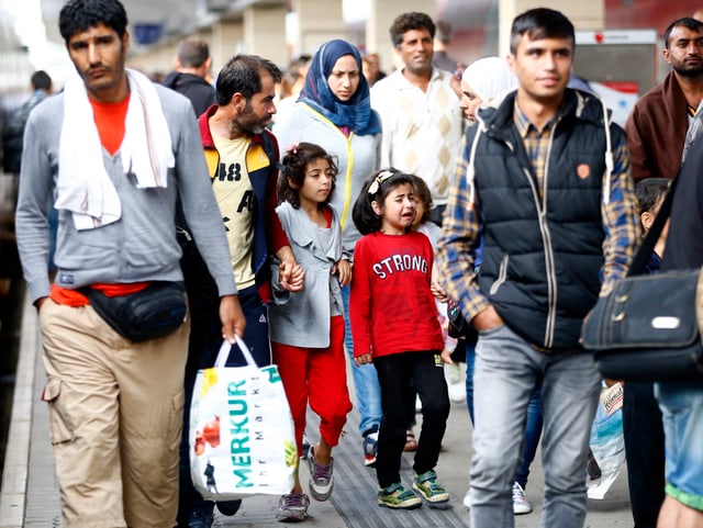 Weinendes Mädchen inmitten von Flüchtlingen.