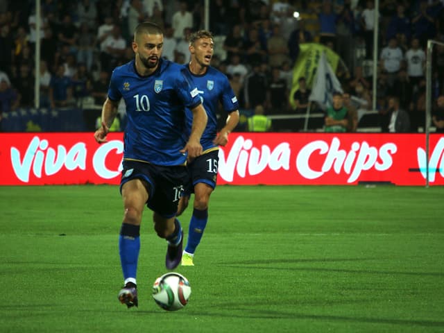 Fussballspieler in blauen Trikots auf dem Spielfeld.