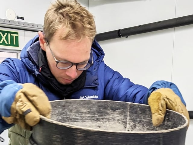 Auf dem Bild ist Jakob Schöttner beim Pulverschnee-Sieben zu sehen.