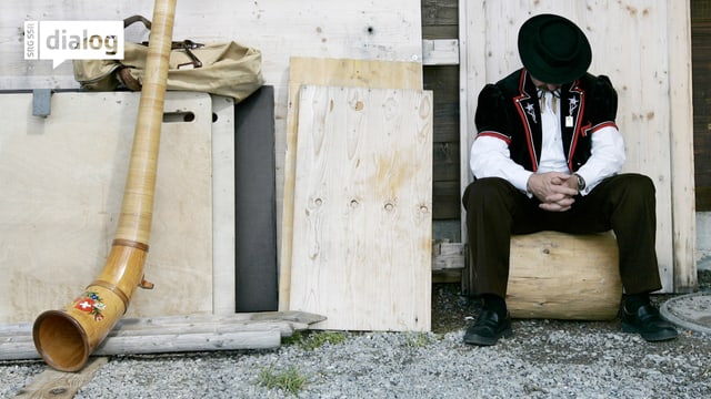 Ein müder Alphornbläser ruht sich am Alphornfest auf der Mennlichen-Bergwiese bei Wengen im Berner Oberland aus