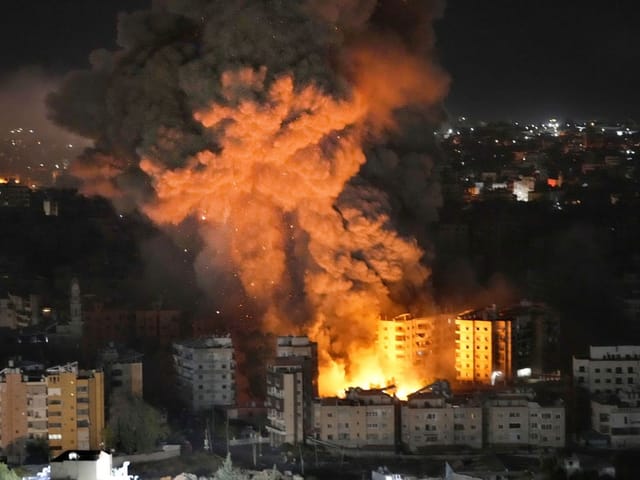 Nächtliche Explosion mit Rauch und Feuer in einer Stadt.