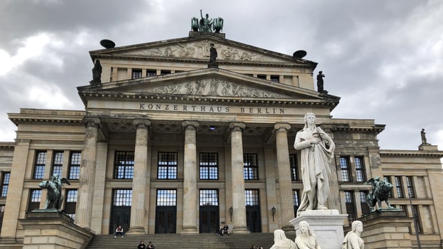 Ein grosses, graues Konzerthaus mit Säulen und Statuen.