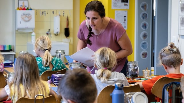 Lehrerin steht in einer Schulklasse