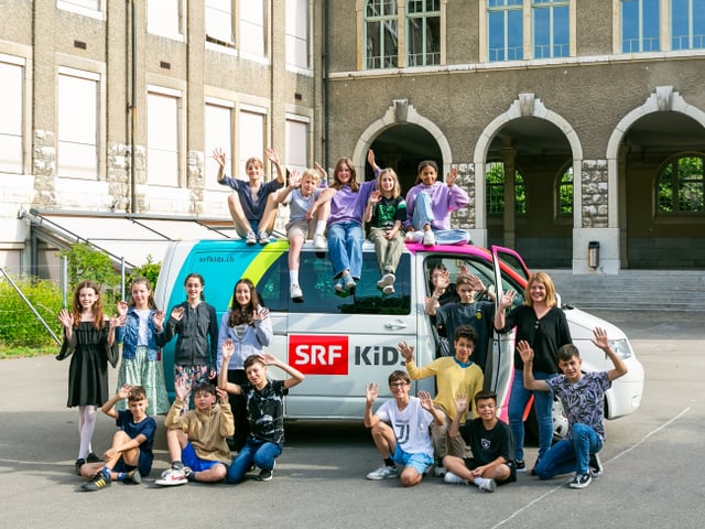 Die Klasse 6C steht vor dem SRF Kids Bus und winkt.