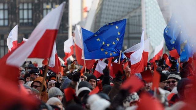 Menschen demonstrieren und halten polnische Flaggen hoch 