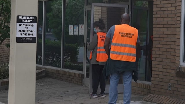 Zwei Personen mit orangen Westen.