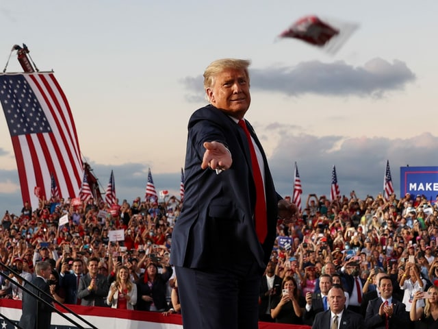 Donald Trump throws a mask to the audience at a campaign rally in Florida.