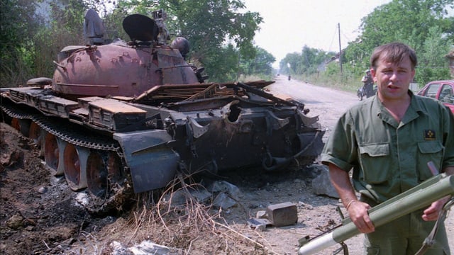 Ein kroatischer Soldat steht neben einem zerstörten serbischen Panzer, aufgenommen am 6. August 1995 60 Kilometer südlich von Zagreb.